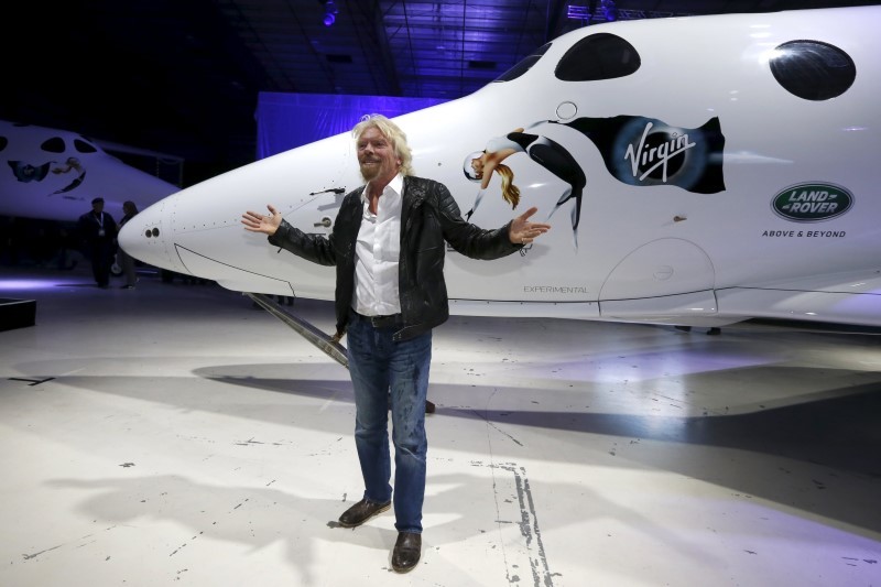 Richard Branson posing with the new Virgin Galactic passenger spacecraft